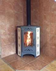 Недорогая печь-камин Бавария угловая с плитой незабудка Амазонка бай фото в интерьере в Молодечно